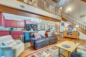 Relax in this stylish living area with a leather sofa, coffee table, and dining table.
