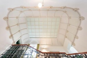 A grand staircase with ornate railings and a glass ceiling.