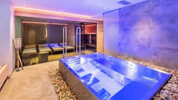 Un espace spa comprenant un bain à remous, des sièges et un mur à surface texturée.