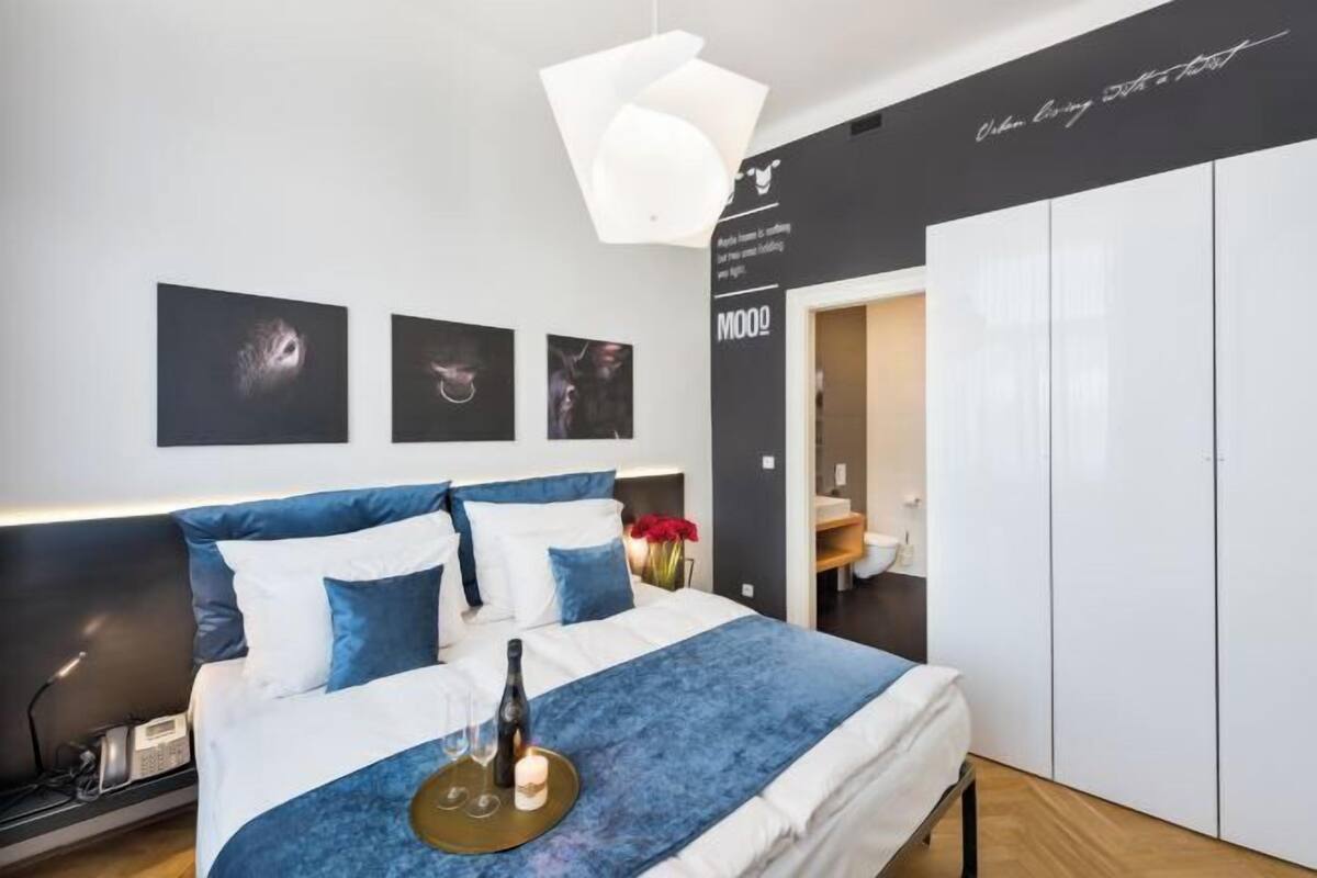 A modern bedroom with a bed, bedside table, and a wardrobe.