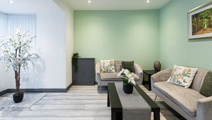 A living room with a sofa, a coffee table, and a potted plant.