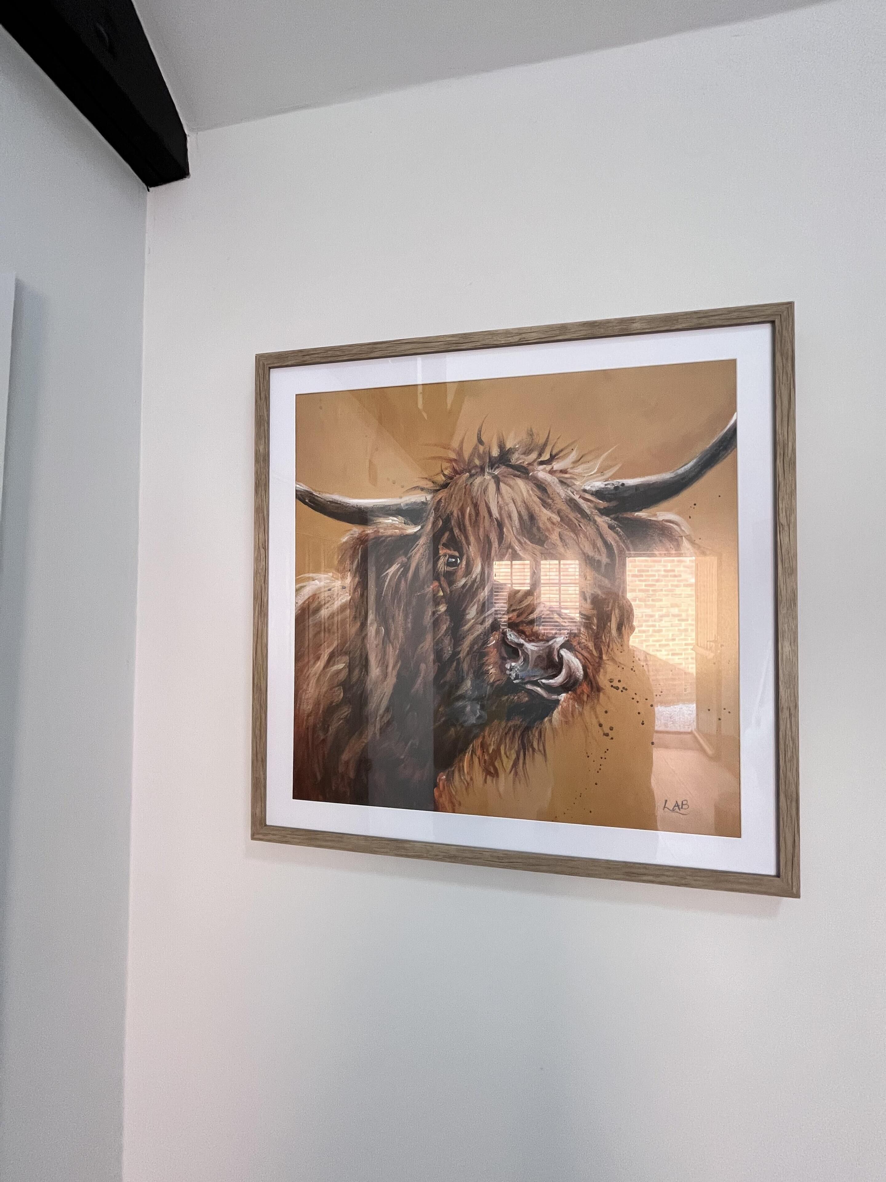 A framed painting of a bull on a white wall.