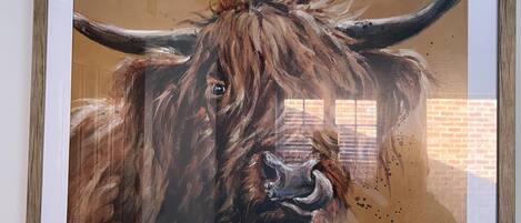 A framed painting of a yak with a wooden frame.