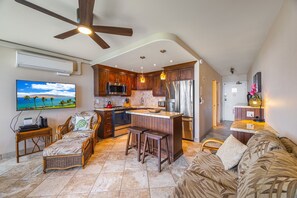 A spacious kitchen with a central island, wooden cabinets, and modern appliances.