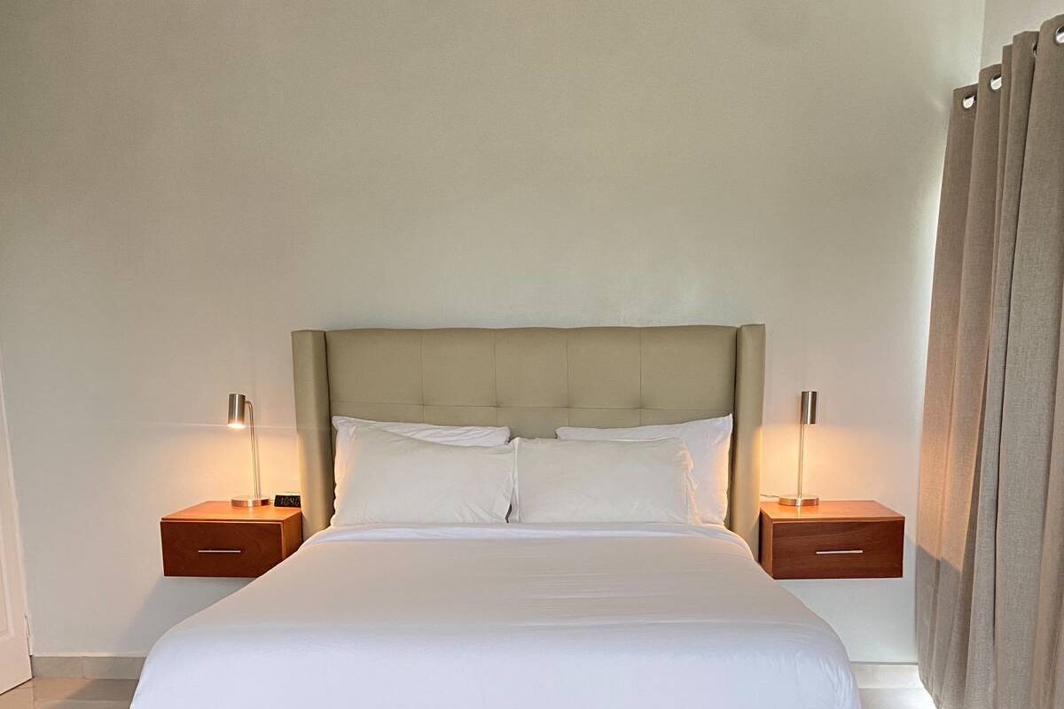 A large bed with a wooden frame, two bedside tables, and a headboard.