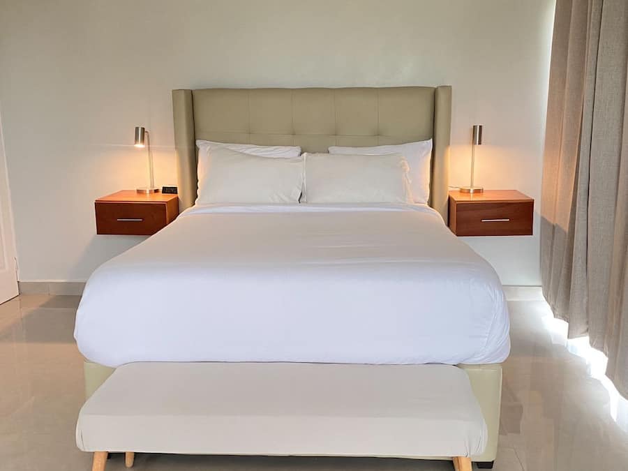 A large bed with a wooden frame, two bedside tables, and a headboard.