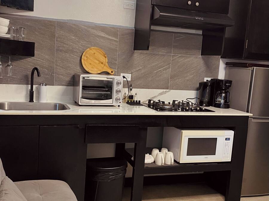 A compact kitchen with a toaster, microwave, and gas stove.