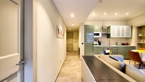 A modern kitchen with a dining area, featuring a long counter, a microwave, and cabinets. - GuestReady - Manor Place Basement (Edinburgh)