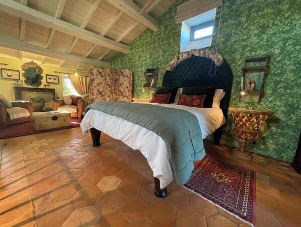 Cozy retreat with a large bed, wooden ceiling, and patterned rug.