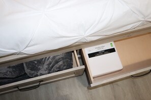 A comfortable bed with a drawer below, offering a soft sheet set.