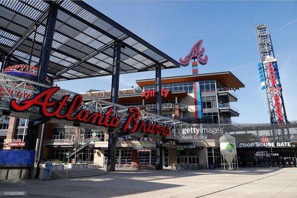 The Atlanta Braves stadium entrance with a prominent 'Atlanta Braves' sign, a covered walkway, and the 'Chop House Gate' sign.