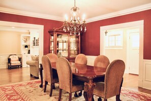 A dining room with a wooden table, six chairs, a chandelier, and a glass-fronted cabinet. - 7th Ave Manor, Remodeled 1930’s Manor just minutes from Historic Downtown Laurel (Laurel)