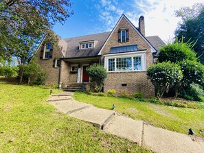 A two-story stone house with a brick facade, a gabled roof, and a front porch. - 7th Ave Manor, Remodeled 1930’s Manor just minutes from Historic Downtown Laurel (Laurel)