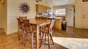 Una cocina amplia con armarios de madera, una isla grande y un comedor con mesa y sillas de madera.