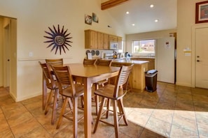 Una cocina amplia con armarios de madera, una isla grande y un comedor con mesa y sillas de madera.