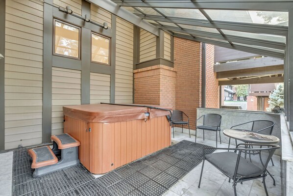 A covered patio with a hot tub, seating area, and a view of the street. - Convenient Mountain Retreat at the Canyon Racquet Club (Cottonwood Heights)