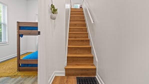 A staircase with wooden steps and a white wall.