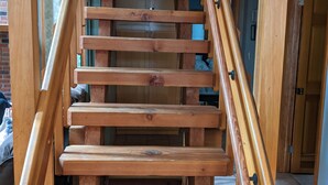 Un escalier en bois, doté d’une rampe, menant à l’étage supérieur.