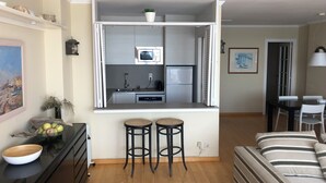 A compact living space with a kitchenette, a dining area, and a sofa. - Amazing sea view near Barcelona (Sant Pol de Mar)