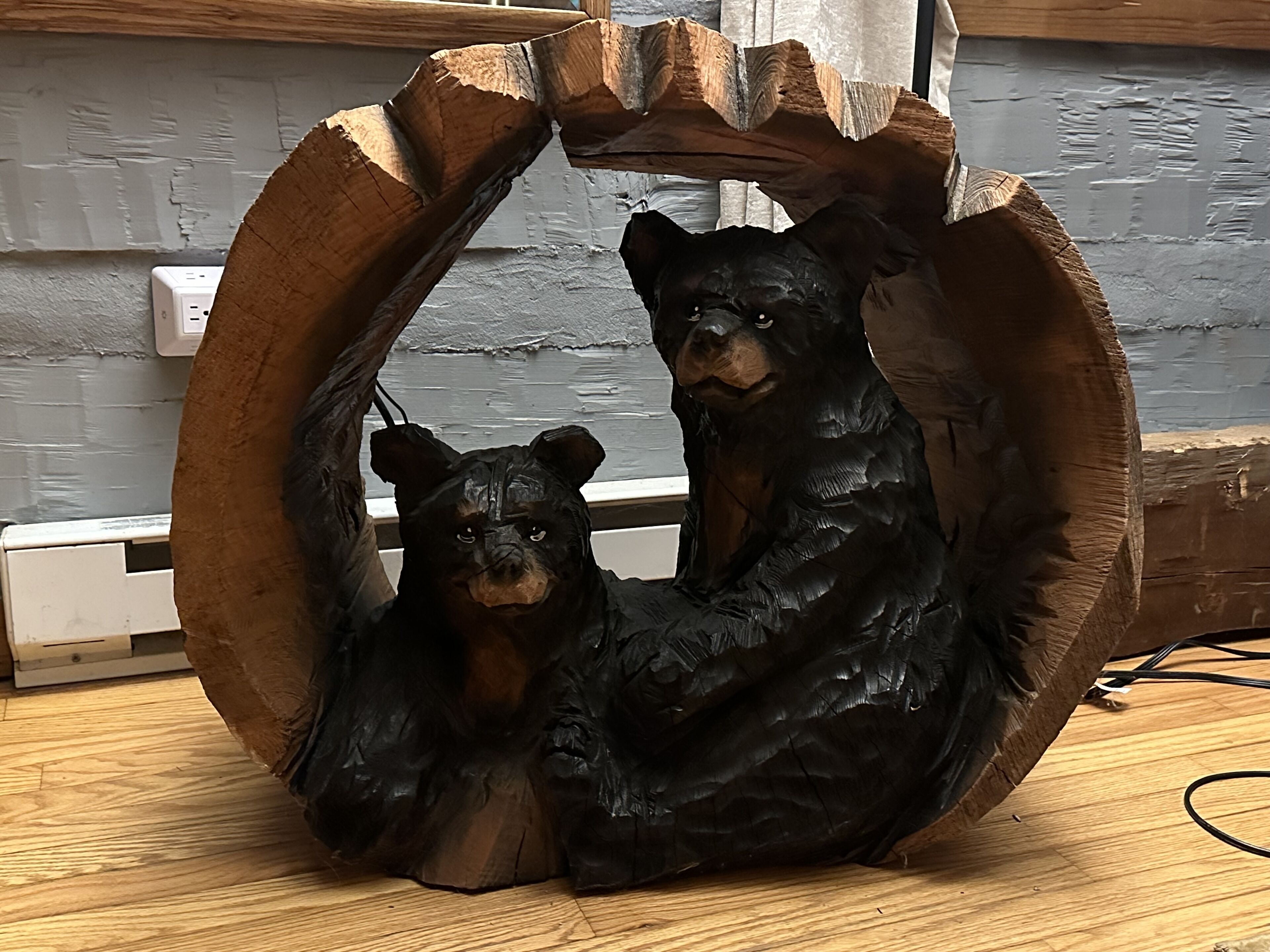 Une sculpture en bois représentant deux ours, disposés en cercle.