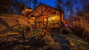 Un rustico chalet con facciata in legno, un portico e una sveglia ben visibile.