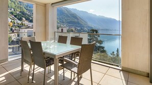 A balcony with a glass table and wicker chairs, overlooking a lake and mountains. - Nice apartment for 6 guests with WIFI, pool, TV, balcony and panoramic view (Montreux)