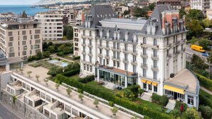 A multi-story hotel with a classic architectural style, featuring a prominent entrance and a landscaped courtyard. - Nice apartment for 6 guests with WIFI, pool, TV, balcony and panoramic view (Montreux)