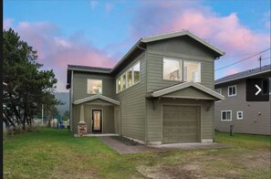 Stunning two-story home with a central entrance, garage, and yard.