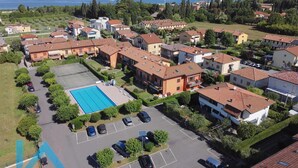 An aerial view of a residential area with houses, a swimming pool, and a parking lot. - Casa Ruby - Pool and tennis court Lazise/Pacengo (Lazise)