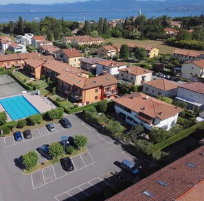 Vista aérea de um bairro residencial com casas, piscina e estacionamento.