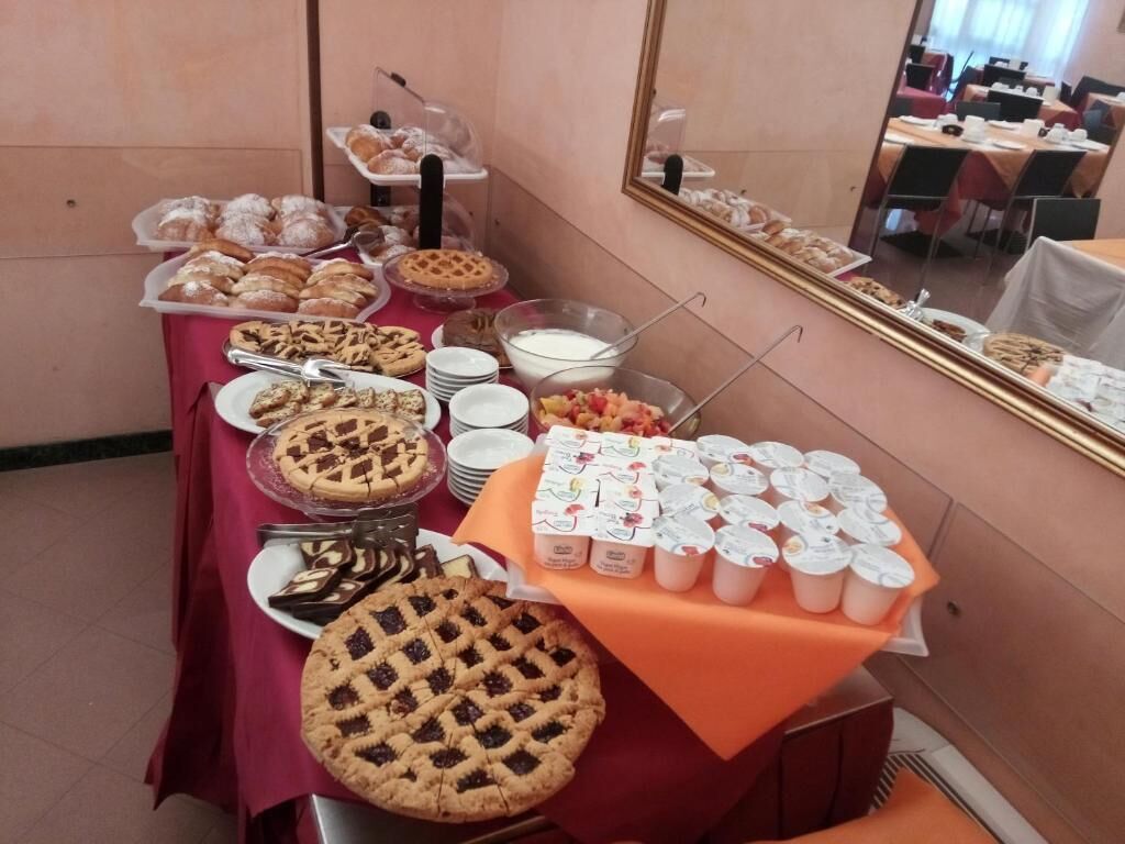 A buffet table with various pastries, pies, and dairy products.