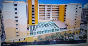 Stunning hotel building with a central atrium and glass facade, set amidst a vibrant urban landscape.