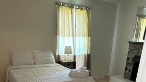 Una camera da letto con un letto, un comodino, una lampada, un camino e una porta.