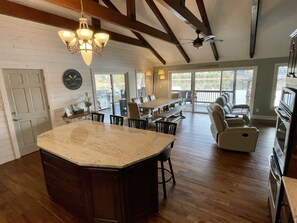A spacious kitchen with a large island, wooden beams, and a view to the outside. - Camm's Lakeside Retreat (Close to Charlotte), Family-Friendly, Boat Available (Belmont)