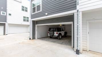 Un garaje residencial con un SUV blanco estacionado en su interior.