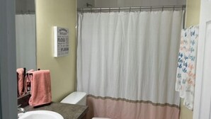 A bathroom with a shower curtain, a sink, and a toilet. - Minutes from the beach! Private pool and game room (Cape Coral)