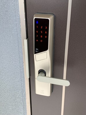 A modern door lock with a keypad and a keyhole. - HOTEL ARENA (Chatan)