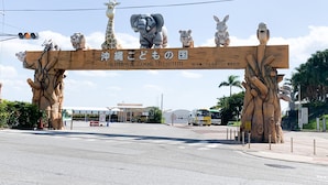 A wooden sign with animal figures and text for Okinawa Zoo & Museum. - HOTEL ARENA (Chatan)