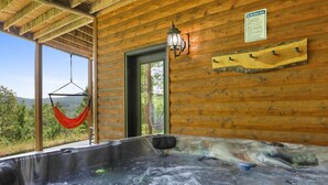 Una baita di legno con idromassaggio, un'amaca e un cartello con le norme di sicurezza per l'idromassaggio.