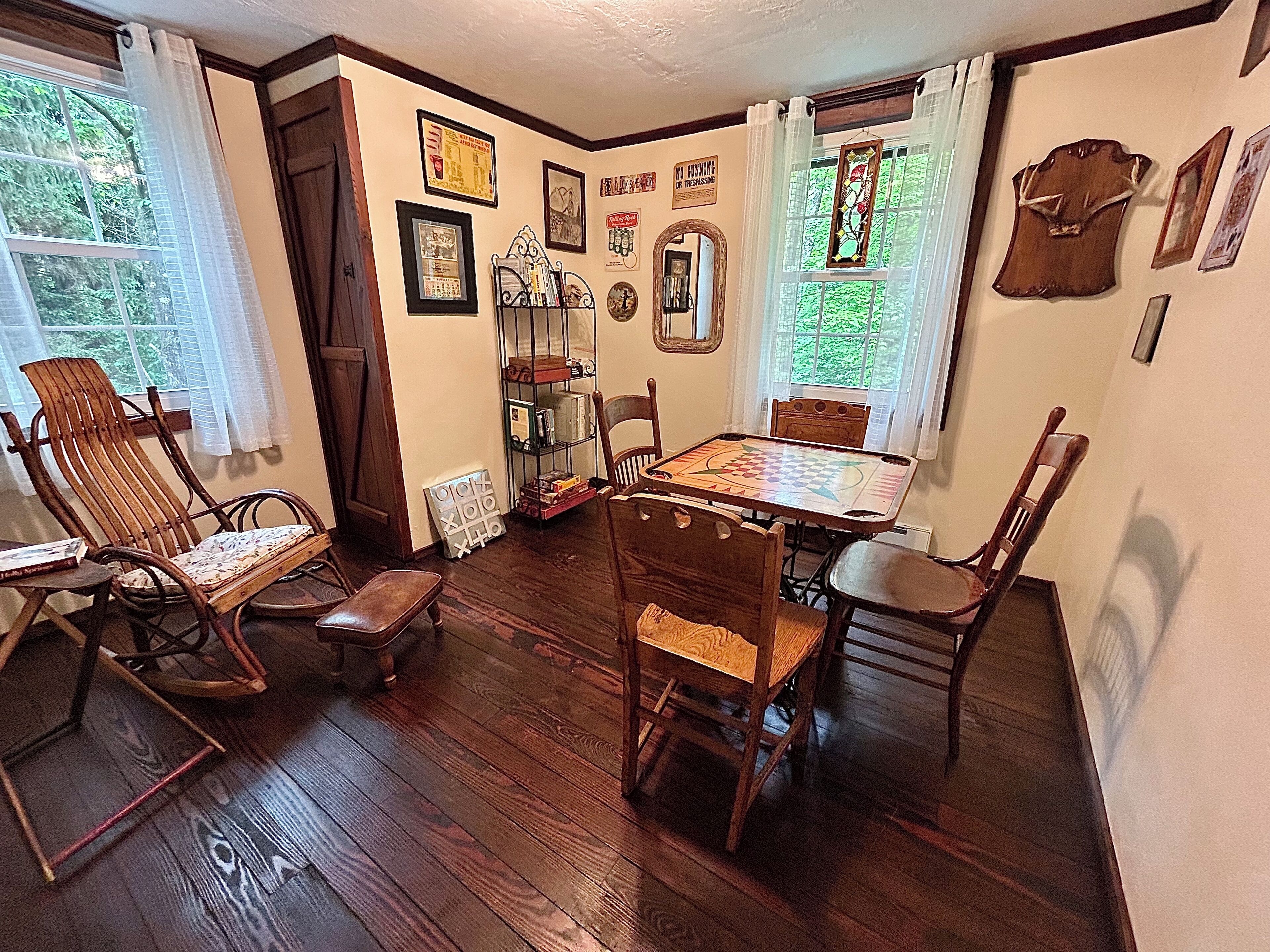 A cozy dining area with wooden furniture, a checkered table, and a bookshelf.