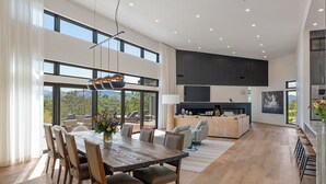 A spacious living area with a dining table, sofas, and a fireplace. - The Quails Crossing-Healdsburg Vineyard Home (Healdsburg)