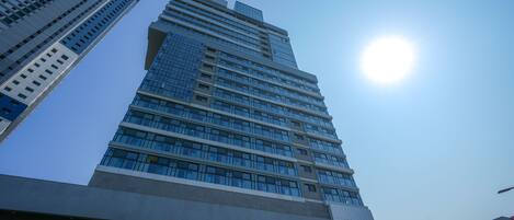 A tall, modern building with a clear sky and sunlight.