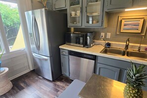 A modern kitchen with stainless steel appliances, a dishwasher, and a microwave.