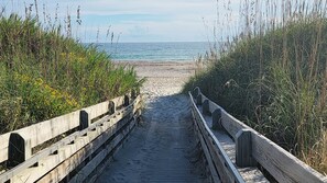 A wooden boardwalk leading to a beach with dense vegetation on both sides. - Gorgeous Water Views, Fenced In Yard, Walk to Beach, Private & Pet Friendly (Atlantic Beach)