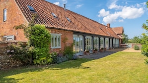 A brick house with a tiled roof, large windows, and a well-maintained lawn. - The Cart Shed (NC) (4), North Creake, Norfolk (North Creake)