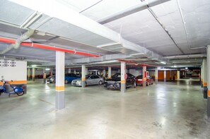 Een parkeergarage met meerdere verdiepingen, diverse auto's en een scooter.