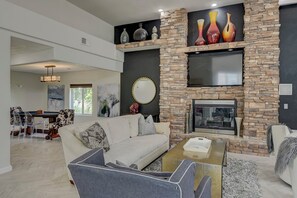 Una sala de estar moderna con chimenea de piedra, un sofá y una mesa de centro.