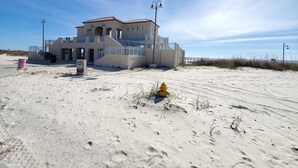 A beachfront building with a staircase leading to the entrance, a yellow fire hydrant, and a clear sky. - Beach Life Condo 135. Pools! Beach! Casinos! FUN! (Biloxi)