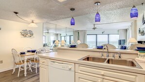 Une cuisine moderne dotée d’un îlot central, d’un lave-vaisselle et d’un grand miroir.