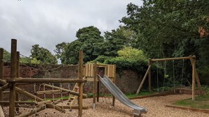 A playground with a slide, climbing structures, and a rope net. - Waterside Cottage - sleeps 8 guests  in 3 bedrooms (Norwich)
